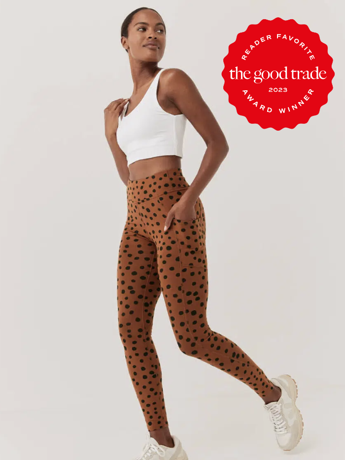 A model wears a white cropped tank and has her hands in the side pocket of a cheetah print pair of cotton leggings.