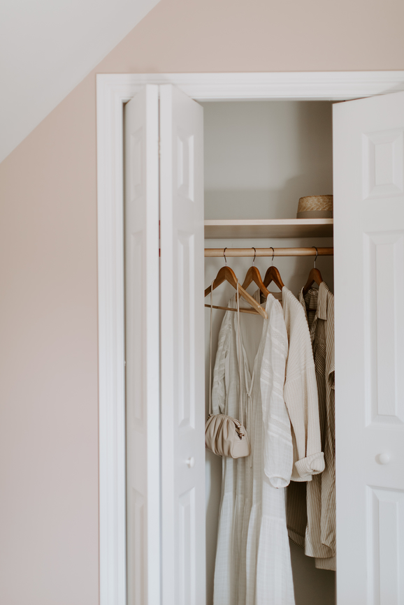 Beautiful and airy wardrobe, filled with off-white dresses and cardigans.