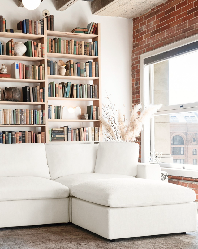 A white 7th Avenue sectional in a loft.